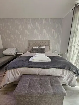 a bedroom with a large bed and a couch at Bright spacious room in Manningtree in Manningtree