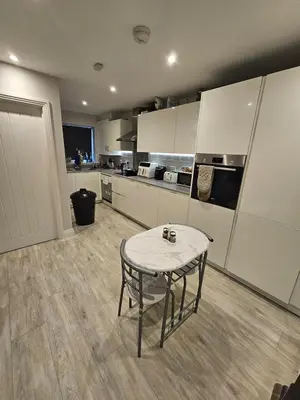 a kitchen with a table in the middle of a room at Bright spacious room in Manningtree in Manningtree
