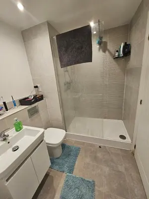 a bathroom with a tub and a toilet and a sink at Bright spacious room in Manningtree in Manningtree