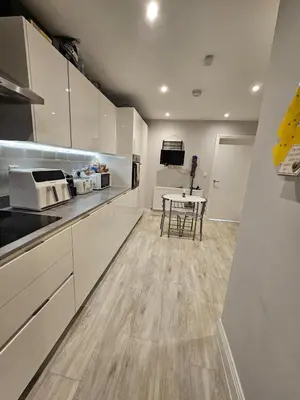 a kitchen with white cabinets and a table at Bright spacious room in Manningtree in Manningtree