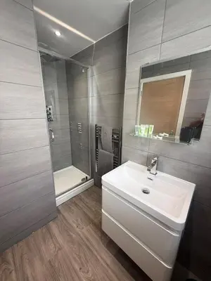 a bathroom with a white sink and a shower at Stylish 3 bed spacious flat in Brentwood