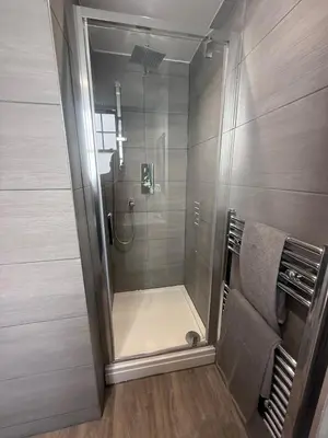 a shower with a glass door in a bathroom at Stylish 3 bed spacious flat in Brentwood