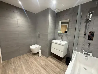 a bathroom with a toilet and a sink and a shower at Stylish 3 bed spacious flat in Brentwood