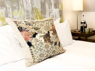 a pillow sitting on top of a bed at The Barn at Orford Lodge by The Suffolk Cottage Collection in Orford
