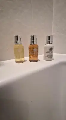three bottles of essential oils sitting on top of a bathroom sink at Hamilton Court in Great Burstead