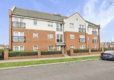 an apartment building with a car parked in front of it at Hamilton Court in Great Burstead