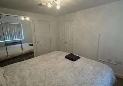 a bedroom with a bed with a black towel on it at Hamilton Court in Great Burstead
