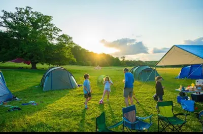 a group of people standing in a field with tents at Farm stay belltent activities in Bramfield