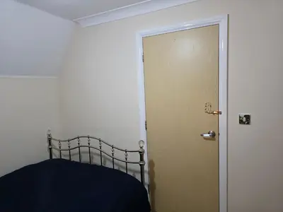 a bedroom with a bed next to a door at Stay Near Colchester twn centre5 in Colchester