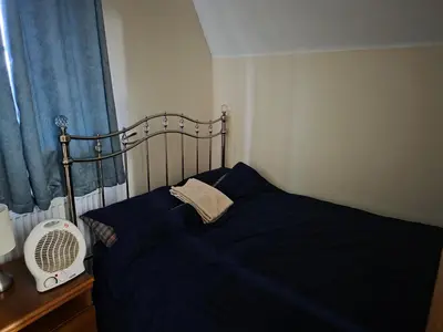 a bedroom with a blue bed and a window at Stay Near Colchester twn centre5 in Colchester