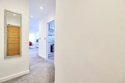 a hallway with white walls and a mirror at Cozy 1 Bed Flat Corringham-Essex in Fobbing