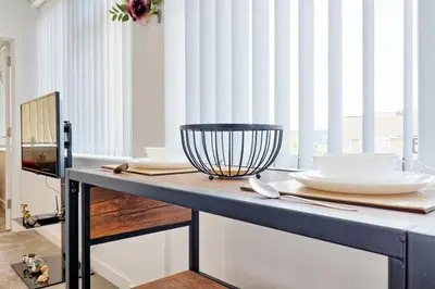 a table with plates and bowls on top of it at Cozy 1 Bed Flat Corringham-Essex in Fobbing