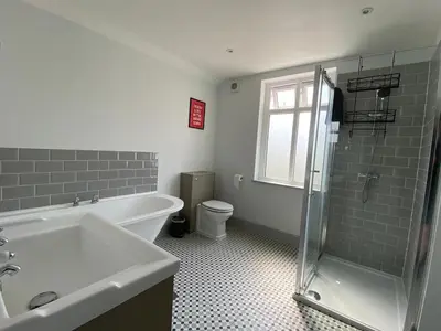 a bathroom with a tub and a sink and a toilet at Three Bedroom Home Close to central Cambridge in Chesterton