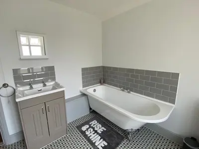 a bathroom with a bath tub and a sink at Three Bedroom Home Close to central Cambridge in Chesterton