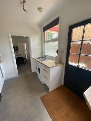 a kitchen with a sink and a washing machine at The Laurels Self Catering Apartment in Chelmsford