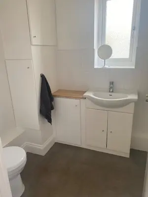 a white bathroom with a sink and a toilet at The Laurels Self Catering Apartment in Chelmsford
