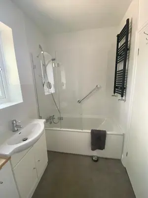 a white bathroom with a tub and a sink at The Laurels Self Catering Apartment in Chelmsford