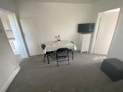 a room with a table with two chairs and a television at The Laurels Self Catering Apartment in Chelmsford