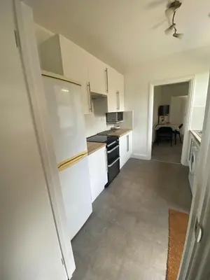 a kitchen with white cabinets and a stove top oven at The Laurels Self Catering Apartment in Chelmsford
