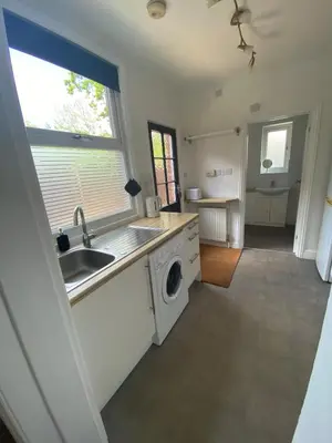 a kitchen with a sink and a washing machine at The Laurels Self Catering Apartment in Chelmsford