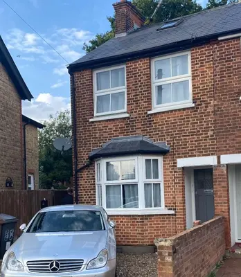 a car parked in front of a brick house at The Laurels Self Catering Apartment in Chelmsford