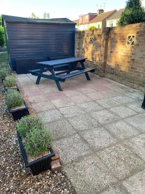 a picnic table sitting on a patio next to a brick wall at The Laurels Self Catering Apartment in Chelmsford