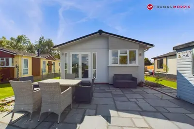 a tiny house with a table and chairs at Lakeside Lodge Retreat with Views in Fenstanton