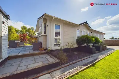 a house with a garden in front of it at Lakeside Lodge Retreat with Views in Fenstanton