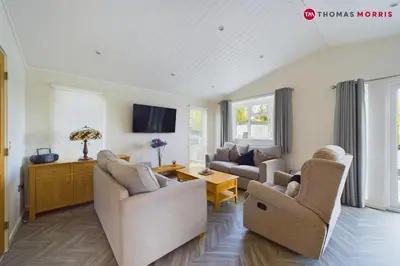 a living room with two couches and a tv at Lakeside Lodge Retreat with Views in Fenstanton