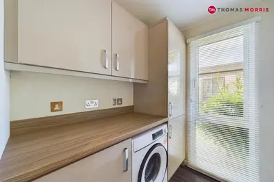 a laundry room with a washer and a window at Lakeside Lodge Retreat with Views in Fenstanton