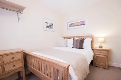 a bedroom with a large bed and two night stands at Camstay Abbey Street in Cambridge