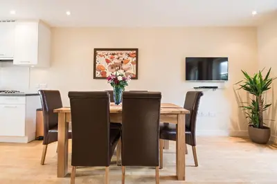 a kitchen and dining room with a table and chairs at Camstay Abbey Street in Cambridge