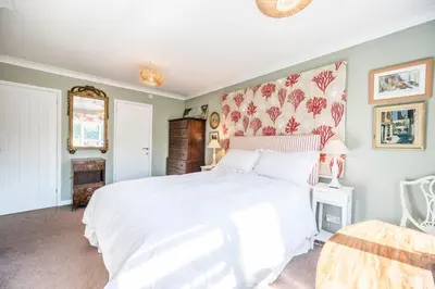 a bedroom with a white bed with a floral headboard at NO 108, private room in Aldeburgh in Aldeburgh