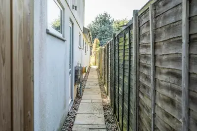 an alley with a fence next to a building at NO 108, private room in Aldeburgh in Aldeburgh