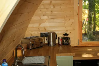 a kitchen with a counter with a microwave and a coffee maker at Highgate Cabin in Takeley