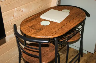 a wooden table with a laptop and a book on it at Highgate Cabin in Takeley