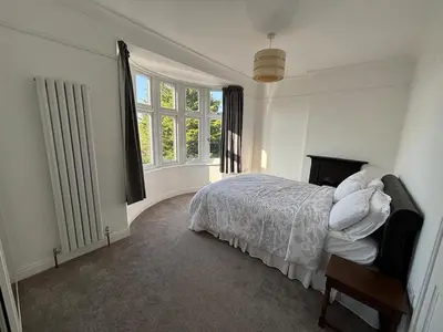 a white bedroom with a bed and a window at Fernleigh - Lovely Self Catering Apartment in Tollesbury in Tollesbury