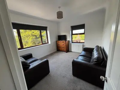 a living room with two leather couches and a television at Fernleigh - Lovely Self Catering Apartment in Tollesbury in Tollesbury