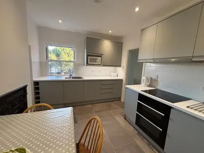 a kitchen with a table and a counter top at Fernleigh - Lovely Self Catering Apartment in Tollesbury in Tollesbury
