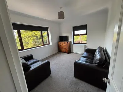 a living room with two leather couches and a television at Fernleigh - Lovely Self Catering Apartment in Tollesbury in Tollesbury