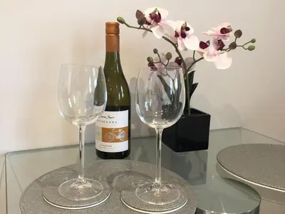 a bottle of wine and two wine glasses on a table at Cosy Loft Retreat off Vibrant Mill Road just minutes from station in Cambridge