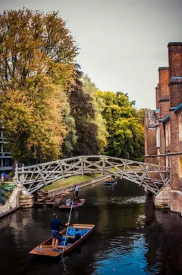 a man is rowing a boat in a river under a bridge at Cosy Loft Retreat off Vibrant Mill Road just minutes from station in Cambridge