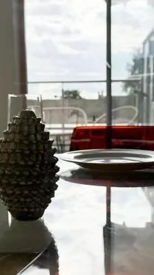 a glass table with a plate on a glass table at The Cambridge Penthouse in Cambridge