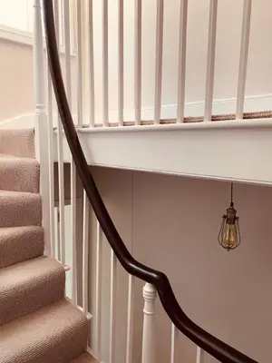 a staircase with a light next to a stair case at Stunning Central Georgian Home in Cambridge