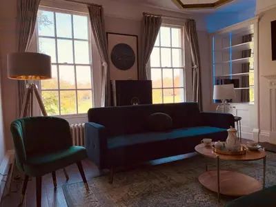 a living room with a blue couch and two chairs at Stunning Central Georgian Home in Cambridge