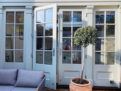 a house with a door and a tree in a pot at Stunning Central Georgian Home in Cambridge