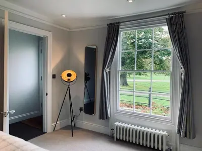 a bedroom with a large window and a tripod at Stunning Central Georgian Home in Cambridge
