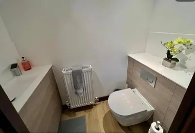 a bathroom with a white toilet and a radiator at Penthouse Mill park train station in Cambridge