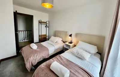 two beds in a hotel room with two beds at Penthouse Mill park train station in Cambridge