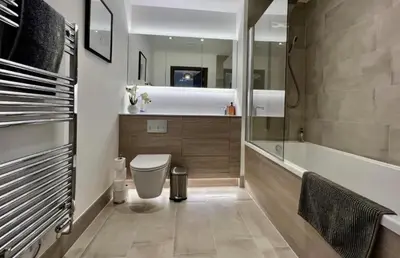 a bathroom with a toilet and a bath tub at Penthouse Mill park train station in Cambridge